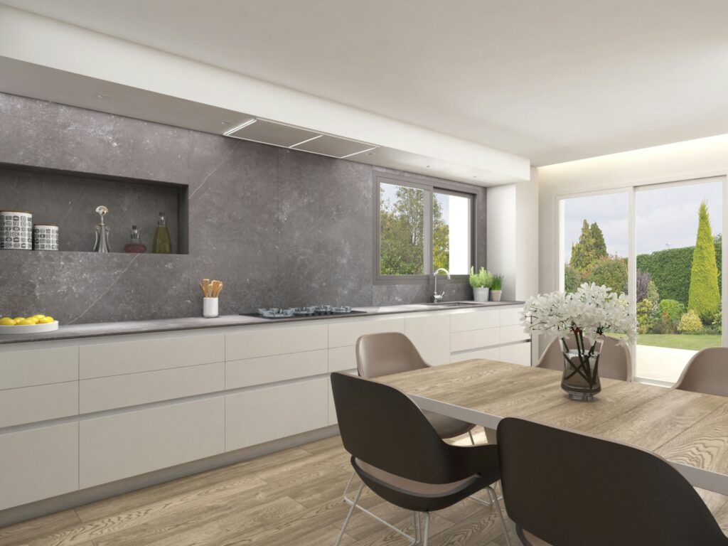 Diseño de Interiores de Cocina Moderna en Barcelona con Muebles de Alta Gama Interiores de cocina moderna en Barcelona, destacan muebles de alta gama, encimera de piedra gris y mesa de comedor de madera clara, con vista a un jardín exterior bien cuidado que resalta la iluminación natural.