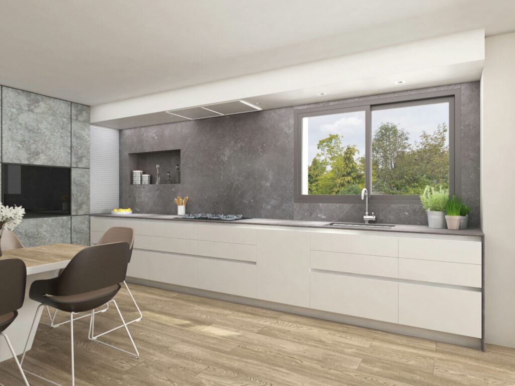 Cocina moderna y contemporánea en diseño de interiores de alta gama en Barcelona Cocina moderna con gabinetes minimalistas en tonos claros, encimera de material de alta calidad, y pared de textura gris. Iluminación natural y vistas al exterior en un proyecto de diseño de interiores en Barcelona.