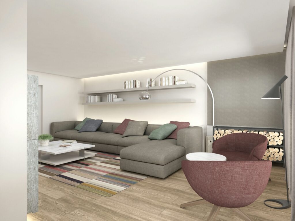 Diseño Interior Moderno de Sala de Estar en Barcelona - Estilo Contemporáneo Sala de estar moderna en Barcelona con sofá seccional gris, cojines coloridos y decoración elegante, resaltando la estética y funcionalidad.