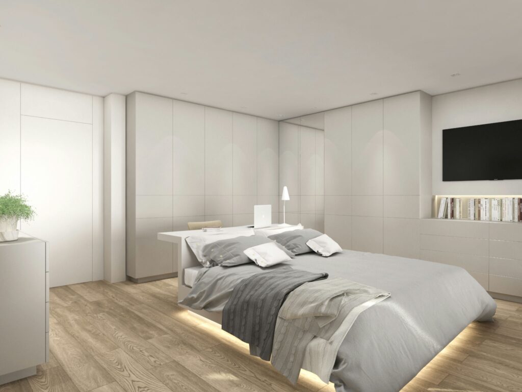 Diseño de interiores moderno en Barcelona: dormitorio de alta gama Interiores de dormitorio moderno en Barcelona, destacando arquitectura de alta gama con mobiliario elegante, cama cómoda con textil gris, y suelos de madera natural.