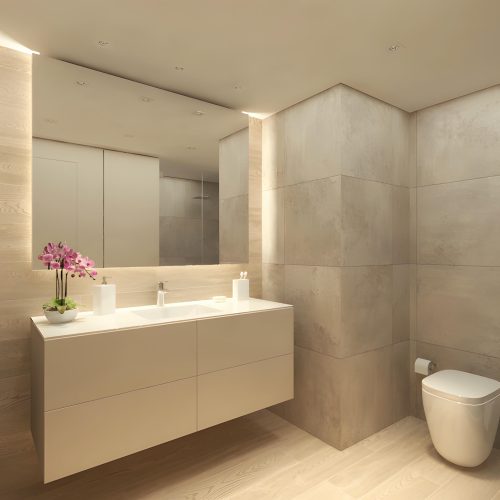 Vista de un baño de alta gama en Barcelona con un diseño moderno y contemporáneo, que incluye suelos de madera clara, mobiliario minimalista, encimera blanca y azulejos en tonos neutros. La iluminación natural resalta la elegancia del espacio decorado con plantas y orquídeas.