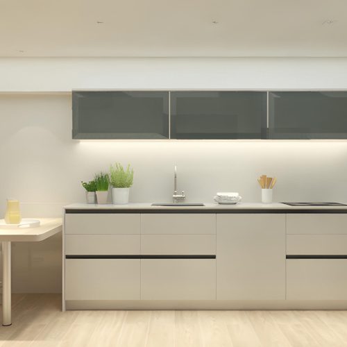 Una cocina moderna que muestra gabinetes elegantes, encimeras de colores claros con un fregadero y una estufa, además de gabinetes con frentes de vidrio. El espacio está acentuado con plantas en macetas y cuenta con una mesa de comedor pequeña con una sola silla, todo dispuesto contra paredes de acabado en madera clara que crean una atmósfera aireada y espaciosa.