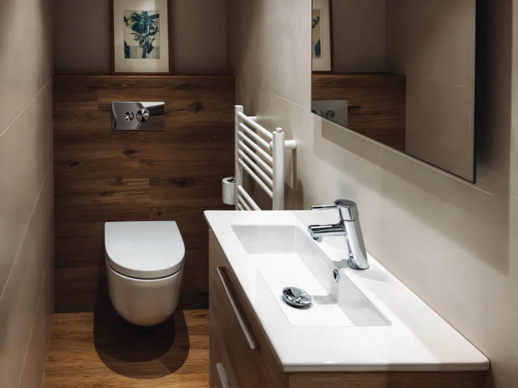 Baño de Diseño Moderno en Barcelona con Acabados de Alta Calidad Baño interior contemporáneo en Barcelona, con suelo de madera, sanitarios minimalistas y lavabo cerámico blanco. Estilo sofisticado con elementos decorativos sutiles y luz natural.