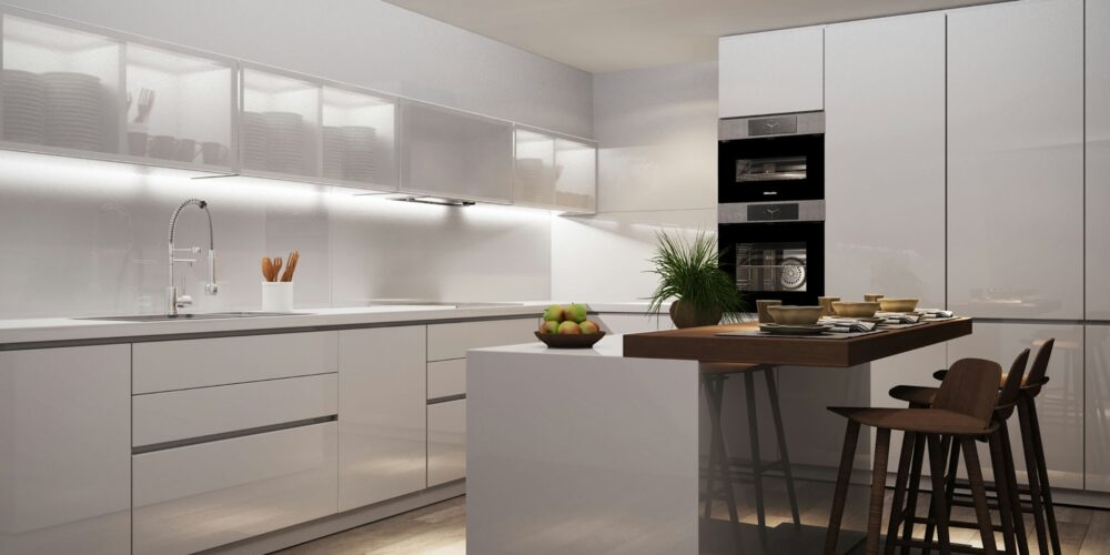 Cocina de lujo en Barcelona con diseño moderno, muebles blancos brillantes, isla central con taburetes de madera y superficies de mármol. Espacio iluminado naturalmente, destacando la estética contemporánea y detalles arquitectónicos elegantes.