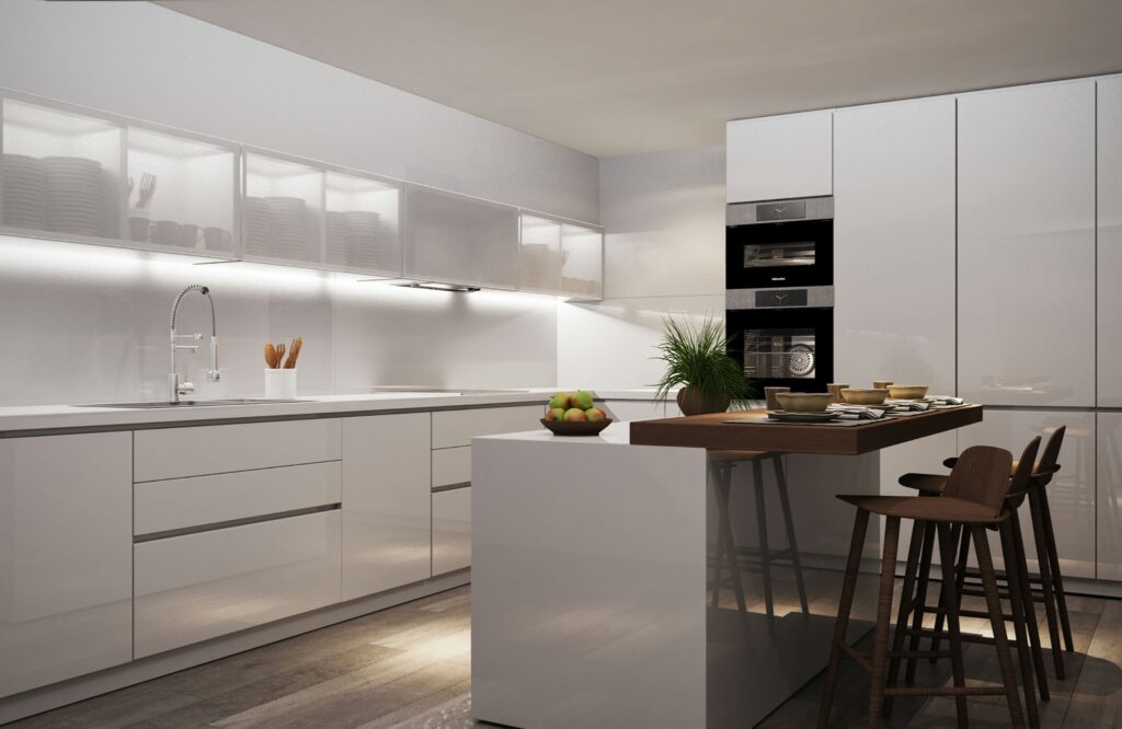 Diseño de Cocina Moderna y Funcional en Barcelona Cocina de lujo en Barcelona con diseño moderno, muebles blancos brillantes, isla central con taburetes de madera y superficies de mármol. Espacio iluminado naturalmente, destacando la estética contemporánea y detalles arquitectónicos elegantes.