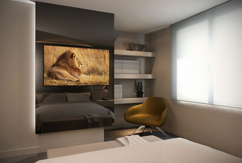 Dormitorio Moderno de Diseño Interior en Barcelona con Estética Minimalista Dormitorio moderno con diseño interior de alta gama en Barcelona, destacando una cama cómoda, un sillón ergonómico amarillo, una televisión montada en la pared mostrando una imagen de un león y estanterías elegantes con libros. Luz natural suave entra a través de cortinas transparentes, resaltando materiales como madera y vidrio.