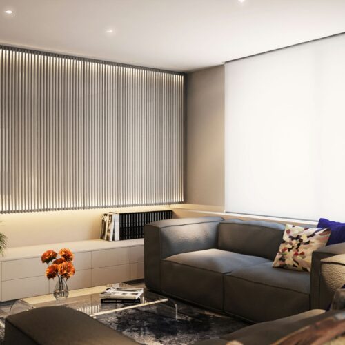 Proyecto de diseño interior en Barcelona que muestra un salón moderno con un sofá gris, almohadas decorativas, plantas y luz natural a través de ventanas grandes, enfatizando la funcionalidad y estética con materiales de alta calidad.