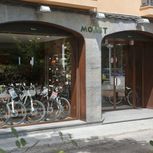 Fachada con arcos de piedra y acero corten en taller Motos Molist, Arbúcies.