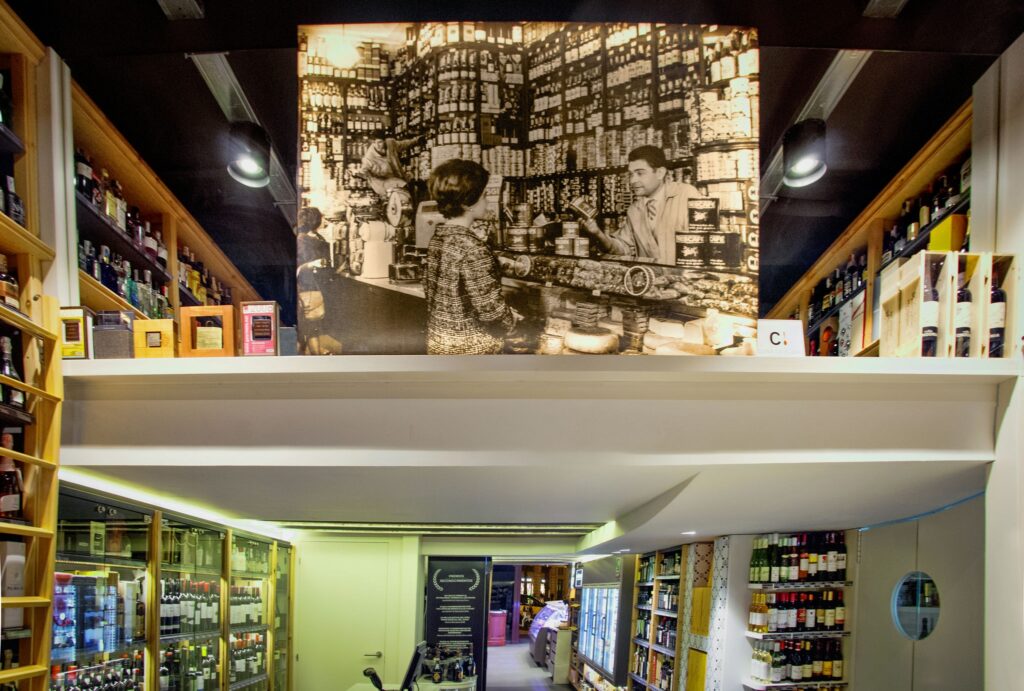 Diseño de interiores moderno en Barcelona con estanterías de madera y fotografía vintage Espacio moderno de diseño de interiores en Barcelona, mostrando estanterías de madera con botellas y una fotografía vintage en la pared superior.