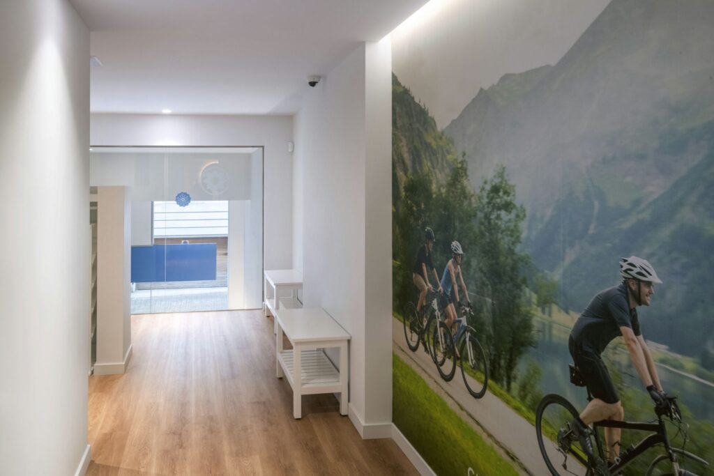 Corredor Moderno en Proyecto de Diseño de Interiores de Alta Gama en Barcelona Corredor elegante con suelo de madera y mural de paisajes en un espacio arquitectónico de alto nivel en Barcelona